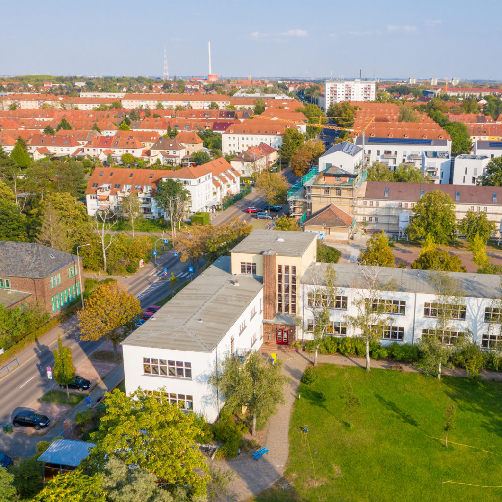 Beide Schulgebäude waren Bestandteil einer monumentalen Planung mit einer Platzanlage und einer großen Kirche als Zentrum der Gartenstadt Gesundbrunnen. 